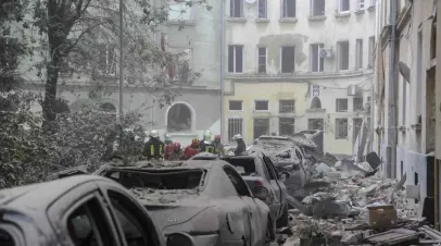 Emergency workers gather outside damaged buildings after a Russian missile attack in Lviv, Ukraine, on Thursday. (Mykola Tys / Associated Press)