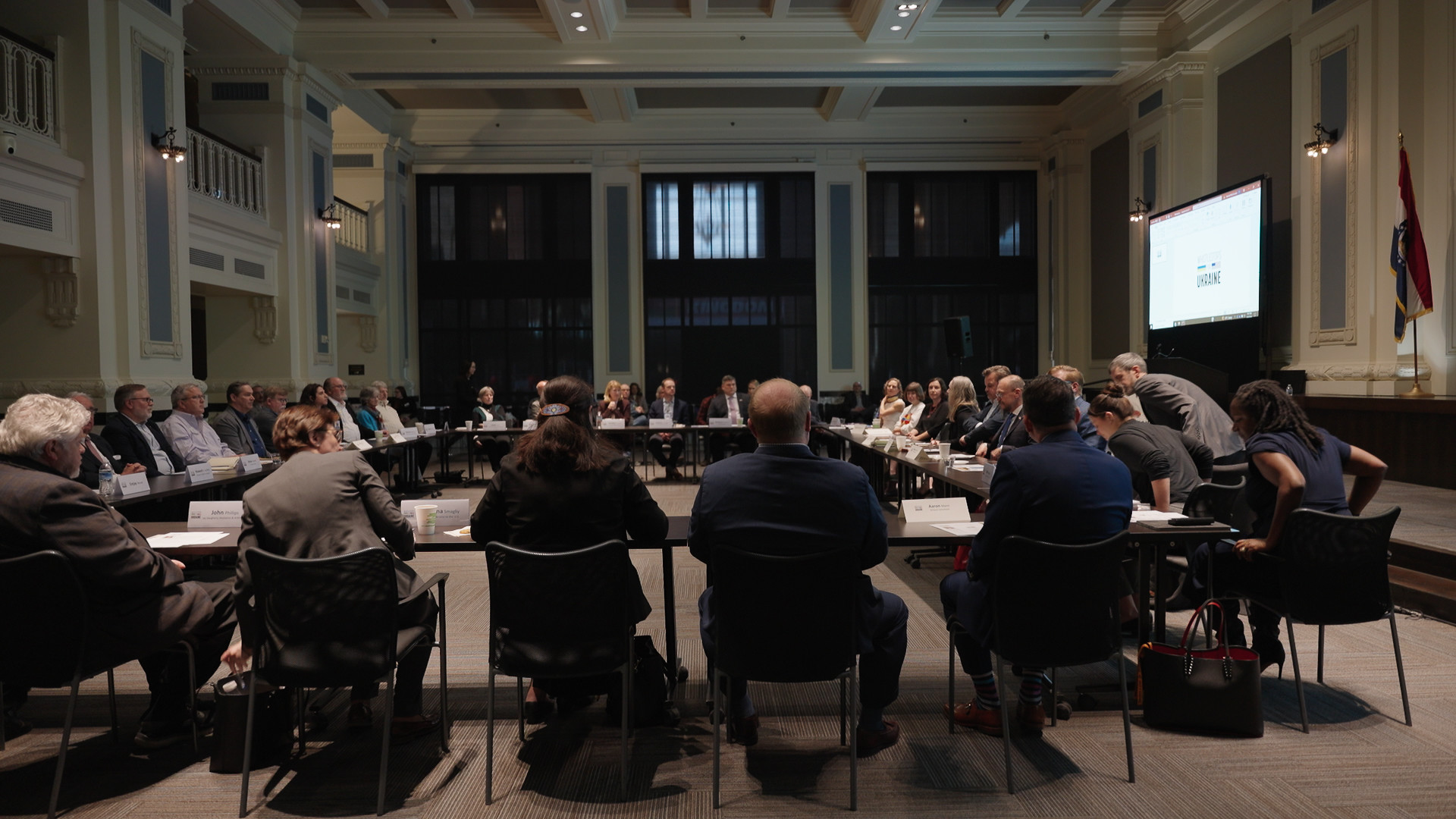 Large group of people sitting around a set of tables set up into a square