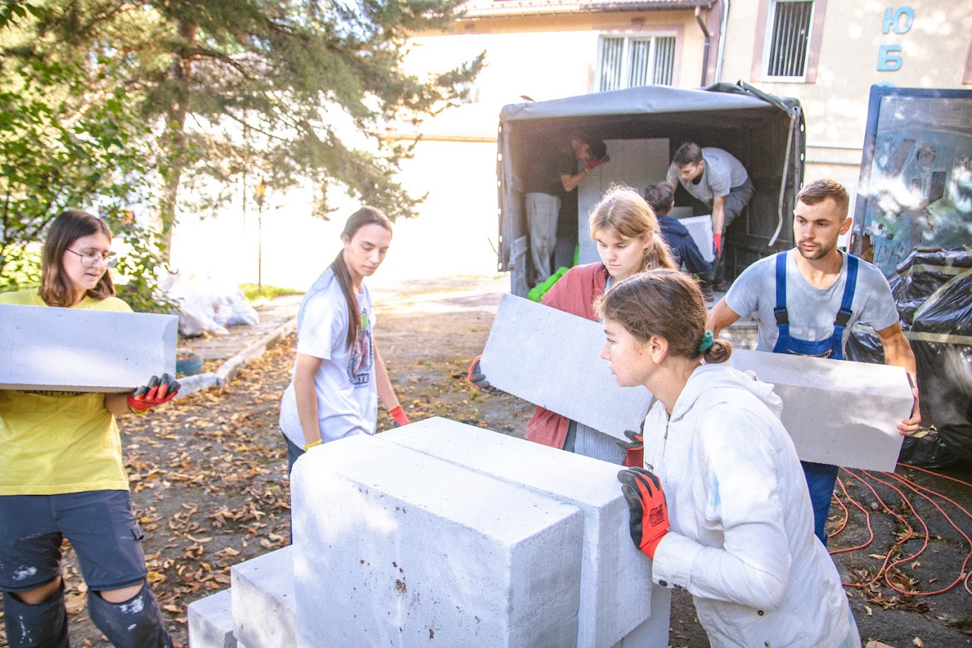 Young people unloading concrete out of a truck