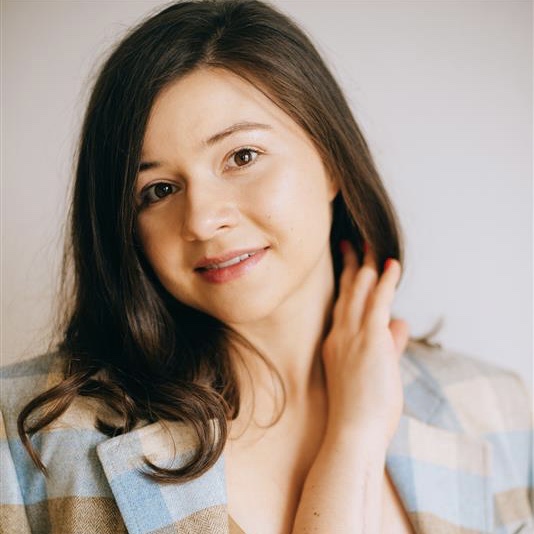 Shows woman wearing a suite with pastel colors