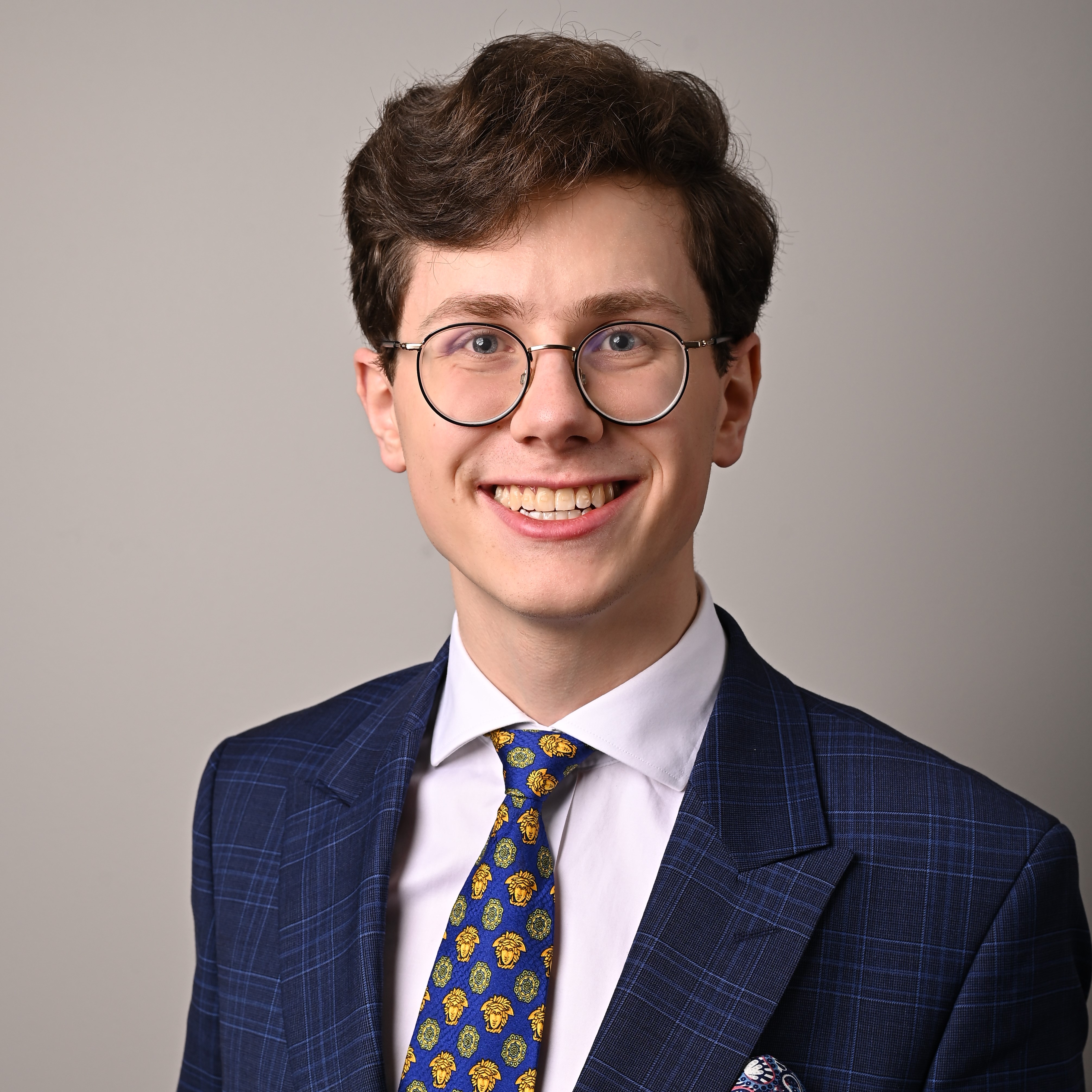 Shows Man is a suit wearing glasses 