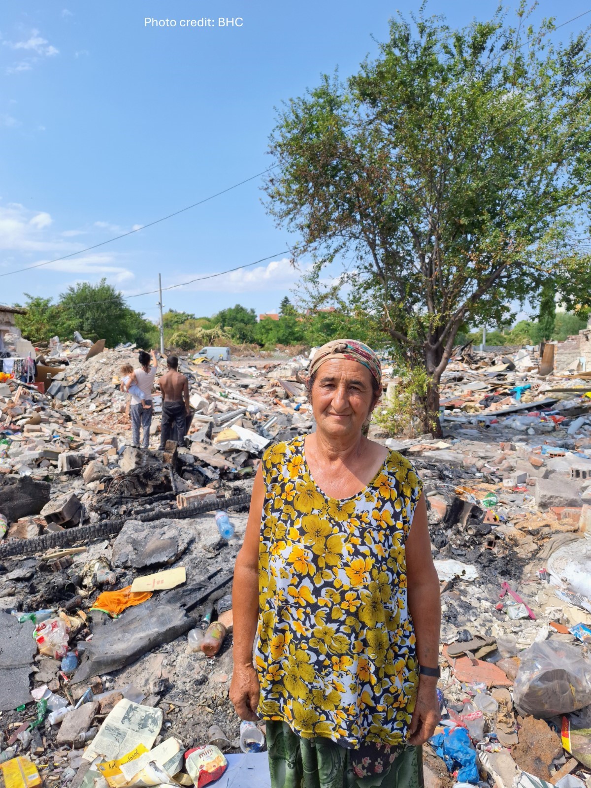A person standing in a pile of rubble

Description automatically generated