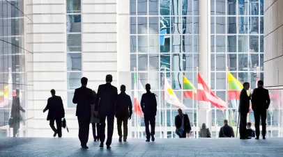 People walking against the light background of an urban landscape