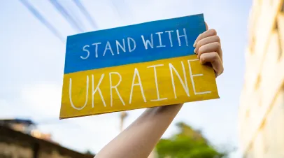 Demonstrator holding "Stand with Ukraine" placard