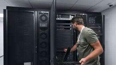 Data Center Engineer Using a Keyboard on a Supercomputer Server Room Specialist Facility with System Administrator