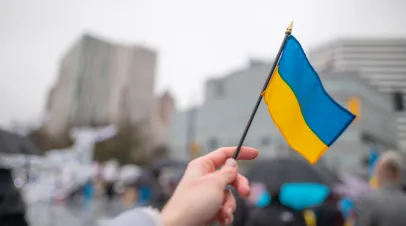 Ukrainian flag with manifestations in background