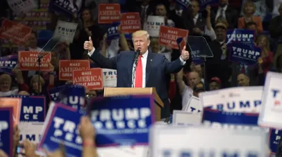 Donald Trump speaking on a podium during a rally