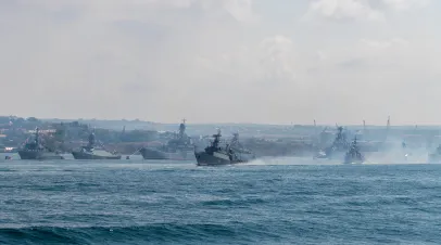 Russia, Sevastopol - July 21, 2021: Group of modern russian warships sails in Sevastopol bay during Russian Navy Day rehearsal in a sunny day next to anchored battle ships. Russia, Sevastopol - July 21, 2021: Group of modern russian warships sails in Sevastopol bay during Russian Navy Day rehearsal in a sunny day next to anchored battle ships.