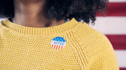Young Gen Z Voter Wearing "I Voted" Sticker After Voting in Election