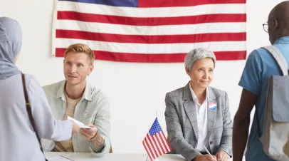 Portrait of two polling station workers registering voters on election day