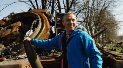 A local partisan, who helped defend his city from the invaders, shows the remains of a Russian convoy of heavy equipment.