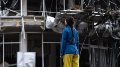 Girl looking at destroyed building