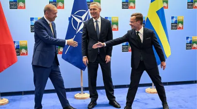 Turkish President Recep Tayyip Erdoğan (left) and Swedish Prime Minister Ulf Kristersson shake hands next to NATO Secretary-General Jens Stoltenberg prior to their meeting, on the eve of a NATO summit, in Vilnius, Lithuania, July 10, 2023. Henrik Montgomery/TT News Agency/AP