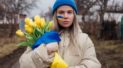 Portrait of Ukrainian woman holding tulip flowers with Ukrainian flag. 