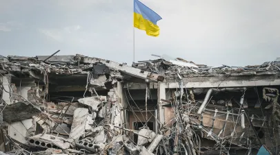 the wreckage of the building and the Ukrainian flag