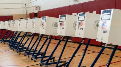 row of voting machines in a gymnasium