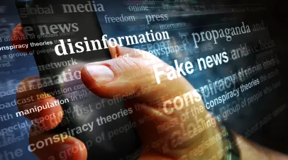 Hand on phone with text saying "disinformation" "fake news" "propaganda" laid over the image