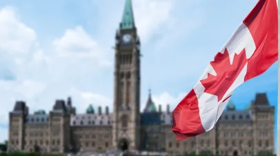 Canadian flag waving with Parliament Buildings hill in the background Ottawa,Ontario, Canada