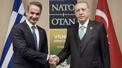 Greece's prime minister Mitsotakis, left, shakes hands with Turkey's president Erdoğan at the Nato summit, prior to another diplomatic visit.