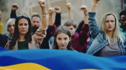 Crowd of activists protesting against Russian military invasion in Ukraine walking in street.
