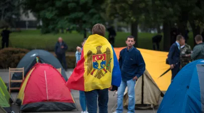 Protest against corrupted government in Republic of Moldova. Young man wrapped in flag of Moldova at "tent town".