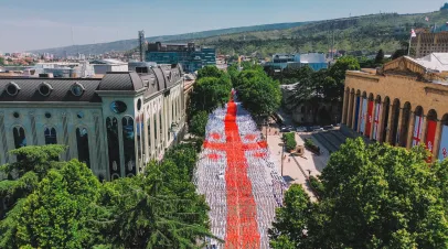 Picture of Rustaveli Avenue in Tblisi with a large Georgian flag made of ribbons strung across it