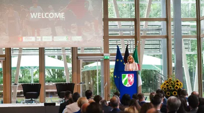 Speaker standing on stage with a woman at a podium 