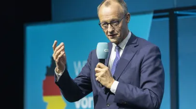 Friedrich Merz speaking into a microphone on stage