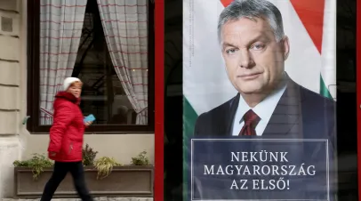 Woman walking by an election poster of Victor Orban