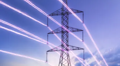 Electric transmission tower with glowing wires against the sunset sky background. High voltage electrical pylon. Energy concept.