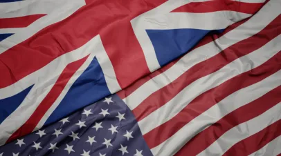 waving colorful flag of united states of america and national flag of great britain.