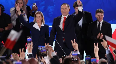 Karol Nawrocki, presidential candidate of the Law and Justice Party (PiS), stands on stage with his wife Marta and their children as they gesture to supporters following the Polish presidential runoff election