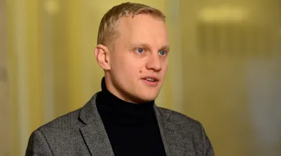 Young blonde man in a grey suit jacket