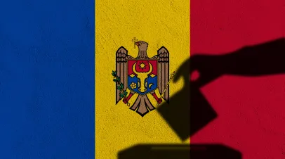 Moldovan flag with the shadow of a person putting a vote into a voting booth superimposed on top