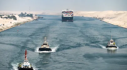Huge cargo ships with pilot boats navigate by Suez Canal, Egypt. Concept of transportation and logistics 