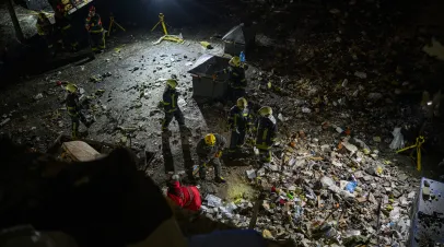 Rescue workers remove rubbles from a residential building that was badly damaged during Russian air strikes