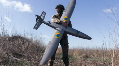A portrait of a soldier from the "Taifun" unmanned aerial vehicle unit holding a new model 'Marsianin' attack drone