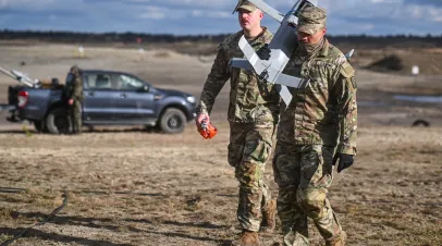 An US army soldier carries an interceptor drone from the Merops system, an AI-powered anti-drone system during a NATO live-fire demonstration of a counter-UAS system on November 18, 2025 in Nowa Deba, Poland. 