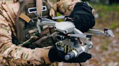 Army soldier hold aerial drone with bomb for fly to enemy positions in military operation.