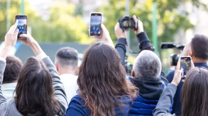 Crowd of people raising smartphones