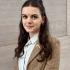 Woman with dark hair and a tweed blazer