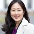 Asian woman with long black hair and a white jacket