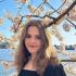 Young woman standing in front of cherry blossoms 
