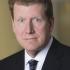 middle aged man in a suit not smiling