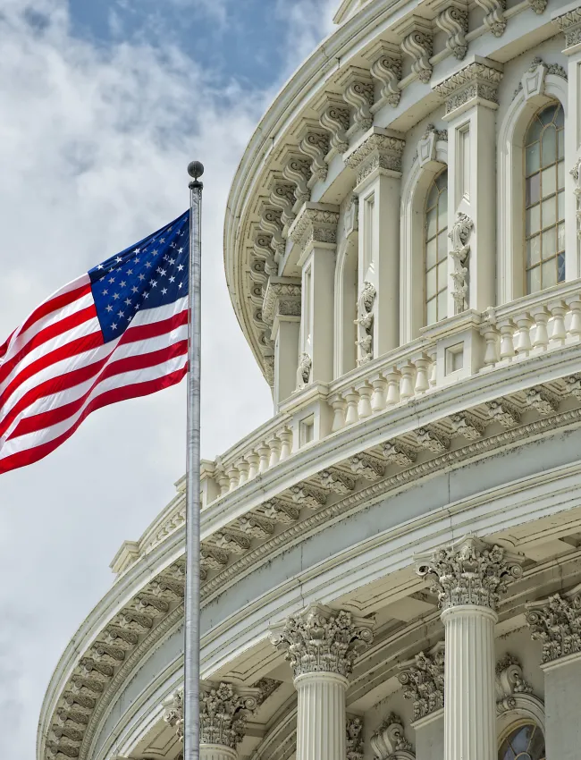 American flag waving outside the U.S. Capitol Building dome. 