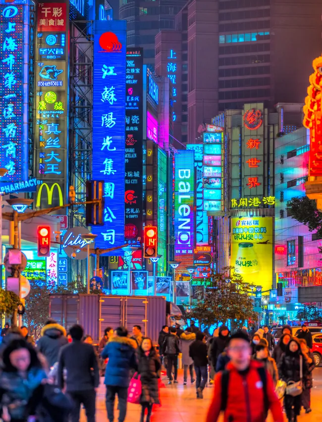 SHANGHAI, CHINA - FEBRUARY 18, 2018: Neon signs lit on Nanjing Road. The area is the main shopping district of Shanghai and one of the world's busiest shopping streets.