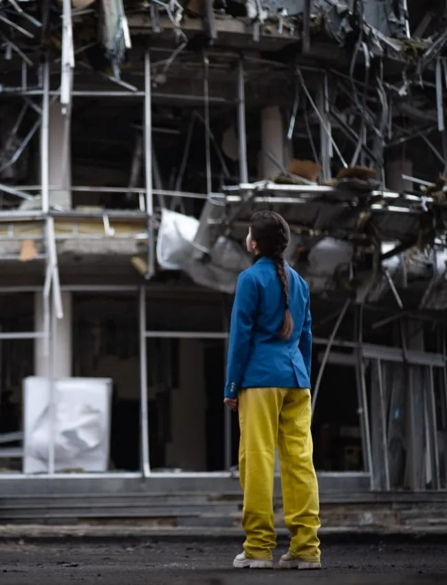 Girl looking at destroyed building