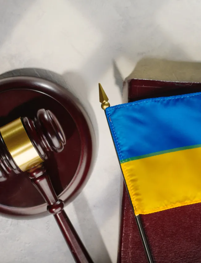 Gavel sitting on a table next to a small Ukrainian flag 