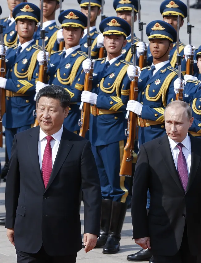 BEIJING, CHINA - JUNE 25: Chinese President Xi Jinping (L) accompanies Russian President Vladimir Putin (R) to view an honour guard during a welcoming ceremony outside the Great Hall of the People on June 25, 2016 in Beijing, China. Russian President Vladimir Putin is in China to discuss more economic and military cooperation between the two countries.