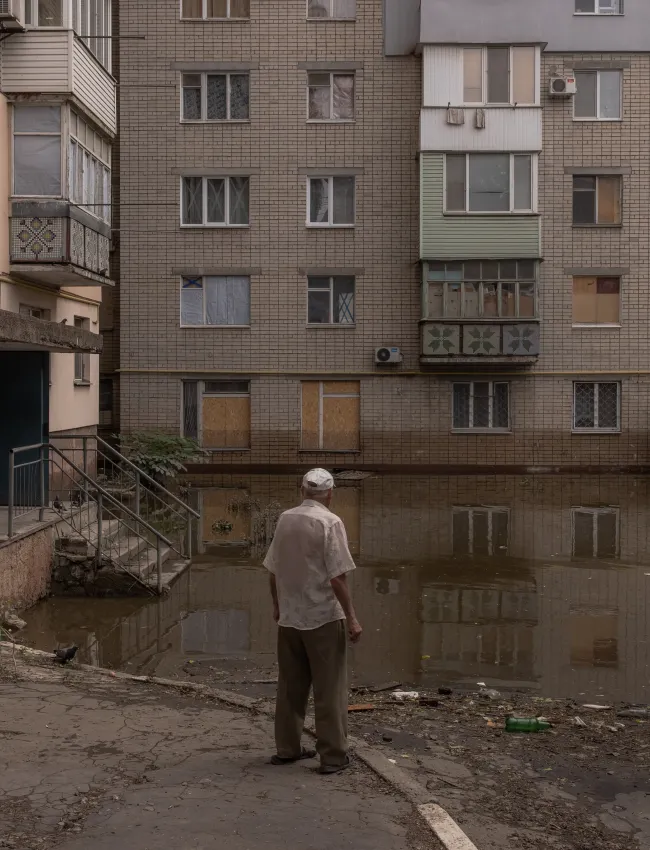 A man looks at a flooded area in front of a residential house on June 10, 2023 in Kherson, Ukraine. 